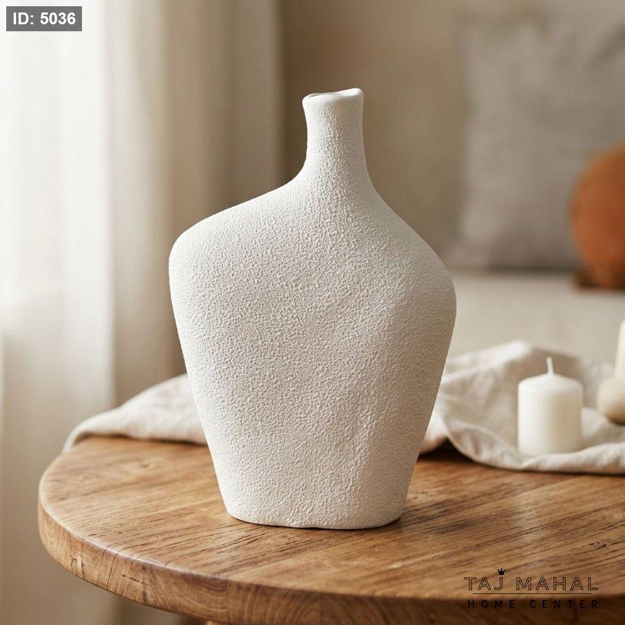 White ceramic decorative vase with a rough surface with a prominent sandy texture