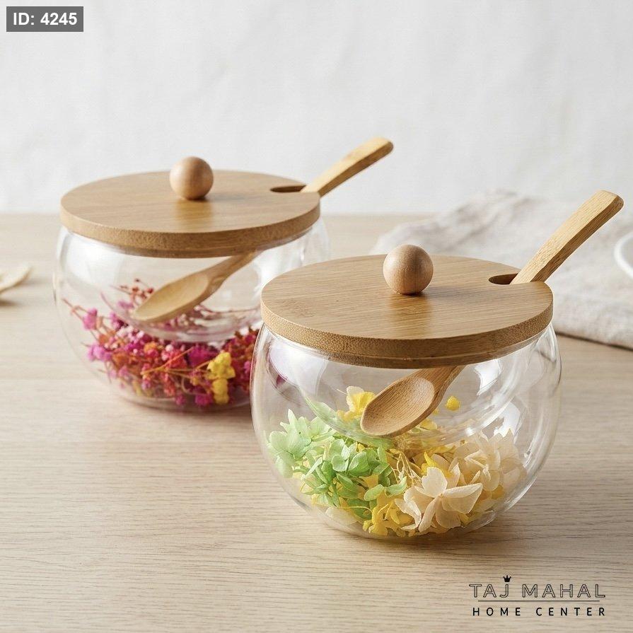 Double-layered glass sugar bowl with dried flowers inside, with a lid and a wooden spoon