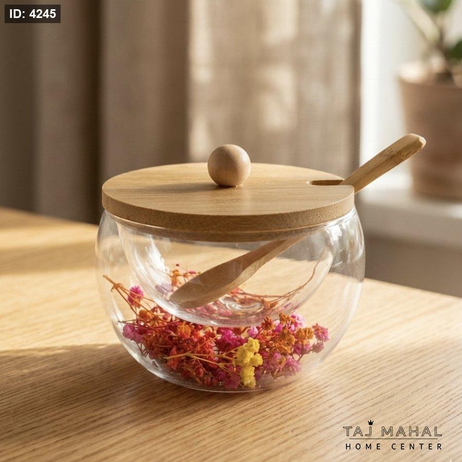 Double-layered glass sugar bowl with dried flowers inside, with a lid and a wooden spoon
