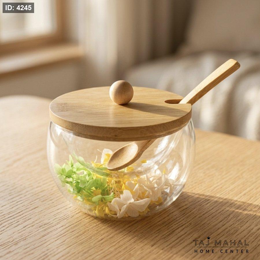 Double-layered glass sugar bowl with dried flowers inside, with a lid and a wooden spoon