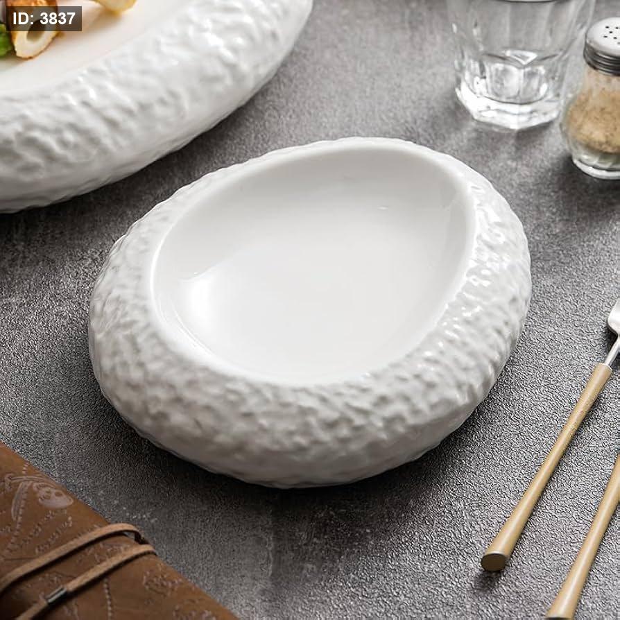 A set of two white oval serving plates with a decorative outer rim