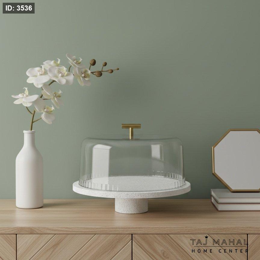 Serving plate with a white base, a transparent glass lid, and a gold handle