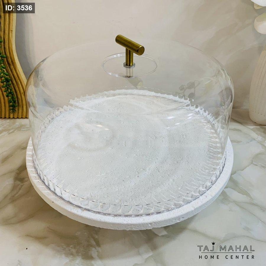 Serving plate with a white base, a transparent glass lid, and a gold handle