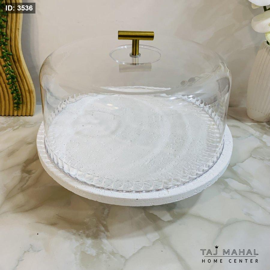 Serving plate with a white base, a transparent glass lid, and a gold handle